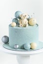 Cake with blue or turquoise velvet cream coating with teddy bear on top. Birthday cake for a little baby with chocolate turquoise