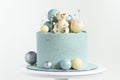 Cake with blue or turquoise velvet cream coating with teddy bear on top. Birthday cake for a little baby with chocolate turquoise