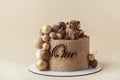 Cake with brown velvet cream coating with teddy bear on top. Birthday cake for a little baby with chocolate brown and golden Royalty Free Stock Photo