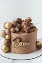 Cake with brown velvet cream coating with teddy bear on top. Birthday cake for a little baby with chocolate brown and golden Royalty Free Stock Photo