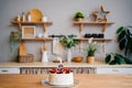 Cake with candle number two and fruit on table on Scandinavian-style kitchen Royalty Free Stock Photo