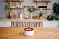 Cake with candle number two and fruit on table on Scandinavian-style kitchen Royalty Free Stock Photo