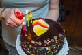 Cake with candles. Woman lights candles on the cake