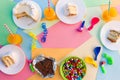 Cake, candy, chocolate, whistles, streamers, balloons, juice on holiday table. Concept of children`s birthday party