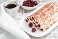 cake with cherries, cream and chocolate on a light wooden background