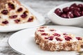 cake with cherries, cream and chocolate on a light wooden background