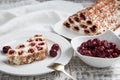 cake with cherries, cream and chocolate on a light wooden background