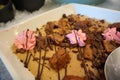 Cake With Chocolate Chunks and Shreds, Chocolate Sauce Drizzles, and Flower Cream