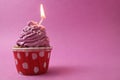 cake cupcake basket with a cap of cream pink lilac with a burned candle. Anniversary 1 year holiday birthday with space