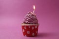 cake cupcake basket with a cap of cream pink lilac with a burned candle. Anniversary 1 year holiday birthday with space