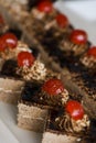 cake decorated with cream, half cherry on a white plate. Selective focus