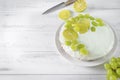 Cake decorated with lime and grapes on a white wooden background, baking, pie, top view, knife, citrus