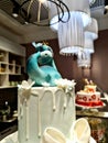 Cake with a figure of an animal under white lamps in the interior