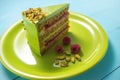 Cake with fruity cream and pistachio decorated with nuts, isolated on wooden background