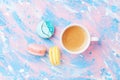 Cake macaron or macaroon and cup of coffee on colorful table top view. Flat lay. Creative breakfast for Woman day. Punchy pastel.