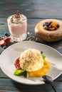 Cake Napoleon puff pastry dessert with strawberry and mango sauce and strawberry milkshake on wooden table Royalty Free Stock Photo