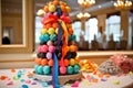 cake pop tower overflowing with colorful cake pops, with cascading ribbon and bow