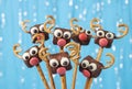 Cake pops Santa reindeers from marshmallows, sweet straw and chocolate on blue background, Idea Christmas treats for Royalty Free Stock Photo