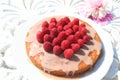 Cake with raspberries and glanzing standing on table in the garden