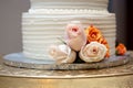 a cake with roses on top of it sitting on a stand