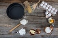 Cake in rural kitchen - dough recipe ingredients eggs, flour, milk, butter, sugar and rolling pin on vintage wooden table from Royalty Free Stock Photo