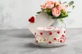 Cake with small hearts and colorful sprinkles on a plate with coffee. Grey stone background. Romantic love concept. Valentine`s d