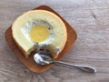 Cake in a small wooden dish and stainless steel spoon