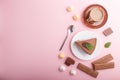 Cake with souffle milk chocolate cream with cup of coffee, meringues on a pink pastel background. top view, copy space