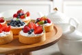 Cake stand with different berry tarts. Delicious pastries