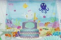Cake table overview decorated with the seabed theme. Children`s party with octopus, seahorse, oysters, corals and colorful