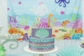 Cake table overview decorated with the seabed theme. Children`s party with octopus, seahorse, oysters, corals and colorful