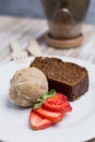 Vegan cake, vegan ice cream and strawberries on a wooden table