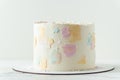 Cake with white cream cheese frosting decorated with multicolored smears on the white background. Blank cake with a free space for