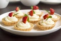 Cakes, cupcakes with fresh fruits (strawberries), whipped cream and mints Royalty Free Stock Photo