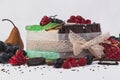 Cakes decorated with raspberries, pears, biscuits, grapes, pomegranates on a white background