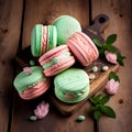 Cakes macaron or macaroon stack on wooden table, pink and green cookis with mint leaves and flowers Royalty Free Stock Photo