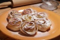 Cakes of puff pastry and apples on a table similar to roses with raspberry syrup Royalty Free Stock Photo