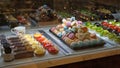 Cakes in showcase. Australian pastry shop with different cookies, macaroons, jelly, cakes with fruits and berries.