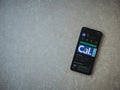 Cal app play store page on the display of a black mobile smartphone on ceramic stone background