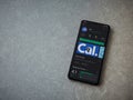 Cal app play store page on the display of a black mobile smartphone on ceramic stone background
