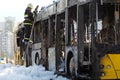 Cal Fire firefighter climbs a ladder by burnt traffic bus
