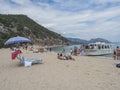 Cala Gonone, Sardinia, Italy, September 9: Cala Luna beach with sunbathing people and tourist ship boat. White sand