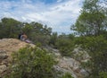 Cala Gonone, Sardinia, Italy, September 8, 2020: middle age couple enjoying view over Gulf of Orosei with green bushes