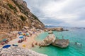 Beach in a natural cove in Sardinia in Italy. Numerous people on vacation during the