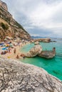 Beach in a natural cove in Sardinia in Italy. Numerous people on vacation during the