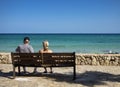 Cala Millor, Palma de Mallorca - Spain - September 20, 2022.Two tourists sitting looking at the Mediterranean sea