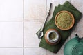 Calabash, bombilla, bowl of mate tea leaves and teapot on tiled table, flat lay. Space for text