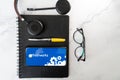 Table top flatlay shot showing mobile phone with Freshworks logo fountain pen spectecles headphones showing this