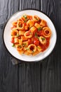 Calamarata pasta with squid sauce a traditional neapolitan recipe close-up in a plate. vertical top view Royalty Free Stock Photo