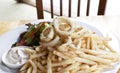 Calamari, mayo dip, fried potatoes, salad Royalty Free Stock Photo